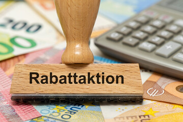 Ein Holzstempel ist beschriftet mit dem Aufdruck Rabattaktion als Symbolbild für die Ankurbelung...