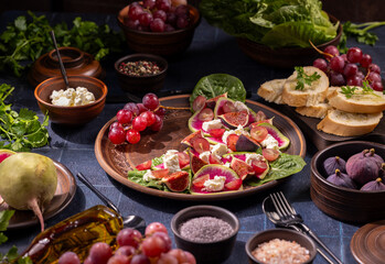 Healthy fig, radish, feta salad with fresh fruits on rustic table