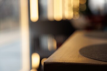 Soft light glimmers on the polished surface of a table, creating a cozy ambiance in the afternoon cafe setting