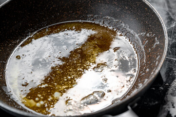 Close-up of a frying pan with melted butter prepared for baking or frying.