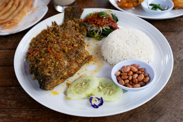Mujair nyat nyat spicy fried tilapia with rice and side dishes Balinese food