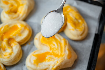 Sprinkling sugar on buns before baking for caramelization