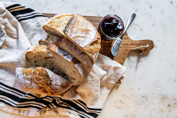 Bread, traditional sourdough, homemade sourdough bread cut into slices on a rustic wooden cutting board, and linen cloth. Healthy organic food. Concept of traditional leavened bread baking methods. 