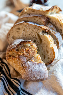 Bread, traditional sourdough, homemade sourdough bread cut into slices on a rustic wooden cutting board, and linen cloth. Healthy organic food. Concept of traditional leavened bread baking methods. 