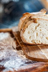 Bread, traditional sourdough, homemade sourdough bread cut into slices on a rustic wooden cutting board, and linen cloth. Healthy organic food. Concept of traditional leavened bread baking methods. 
