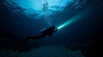 A diver descends into the deep blue, equipped with scuba gear and a powerful light to illuminate the underwater world. Exploring depths. Thrilling underwater adventure.
