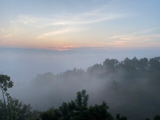 Rainforest ecosystem and healthy environment concept.hills with beautiful clouds in the morning. Summer Mountain with green plants and clouds in the sky. wooden hut on Mountain. Texture of green tree.