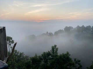 Rainforest ecosystem and healthy environment concept.hills with beautiful clouds in the morning. Summer Mountain with green plants and clouds in the sky. wooden hut on Mountain. Texture of green tree.