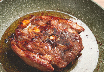 fried steak, veal neck on the bone, cooking meat in a frying pan, top view, no people,