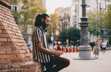 Man dances with closed eyes enjoying music, immersed in sound and movement, embodying confidence, freedom and personal tech connection in city life.