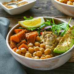 Bowl of chickpeas, salad, sweet potato, salad and avocado