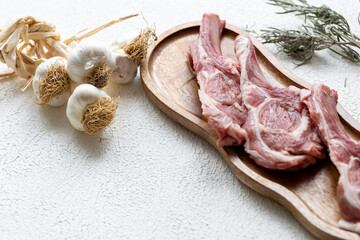 Raw Chops with Garlic and Spices on a Wooden Plate