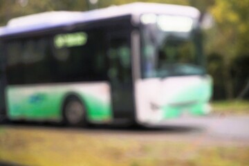 Abstraktes Motiv mit parkendem Bus an Busbahnhof vor Bäumen am Nachmittag i Herbst