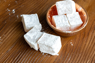 Assorted Turkish Delights in a Copper Bowl on a Wooden Table (Close-Up)
