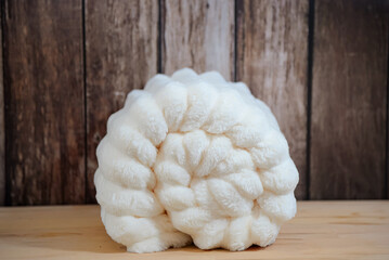 Warm beige plush plaid close-up on wooden background