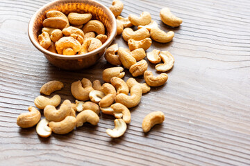 Close-Up of Cashews in a Copper Bowl on a Wooden Surface
