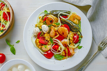Healthy seafood zucchini pasta bowl with shrimp, grilled pepper, and fresh vegetables