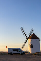 Camper van parked by windmill in Mota del Cuervo at sunset
