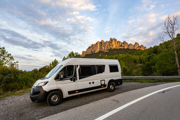 Camper van traveling in Montserrat mountains at sunset