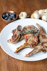 Garlic and Herb Crusted Chops on a White Plate on a Wooden Table
