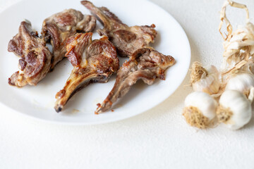 Garlic and Herb Crusted Chops on a White Plate on a Wooden Table
