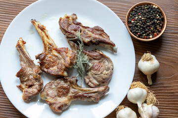 Garlic and Herb Crusted Chops on a White Plate on a Wooden Table
