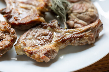 Garlic and Herb Crusted Chops on a White Plate on a Wooden Table
