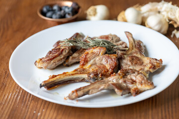 Garlic and Herb Crusted Chops on a White Plate on a Wooden Table
