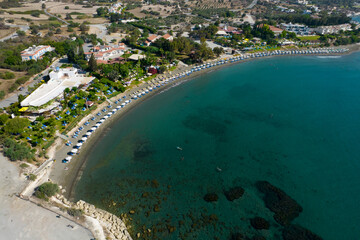 Coastal view of beach umbrellas and sun loungers along a serene shoreline. Governos Beach holiday resort cyprus