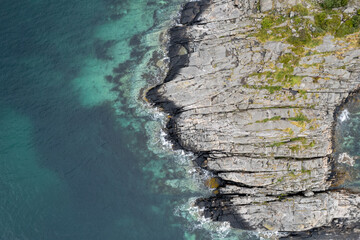 Turquoise water crashing on rocky coastline. Rocky seascape. Drone aerial landscape