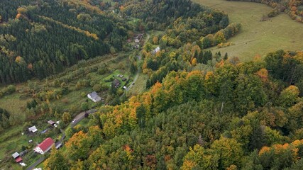 Aerial mountain valley village Travna Czechia autumn descend. Czech Republic, Czechia historically known as Bohemia. Central Europe. Autumn fall season. Farm rural area landscape. Mountain valley.