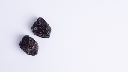 Flat lay two Ajwa dates in isolated white background with ample copy space. Excellent for Iftar meals, Ramadan/Eid promotions, healthy energy ads, and minimal design.
