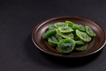Dried green kiwi slices on rustic plate