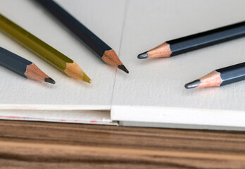 Colored and black pencils, on a notebook, drawing related to art and school.