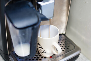 Coffee Machine Dispensing Fresh Espresso into White Ceramic Mug on Drip Tray in Cozy Home Environment