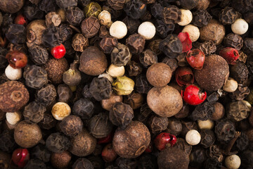 Black, red and white pepper grains as background close up. Spice. Food.