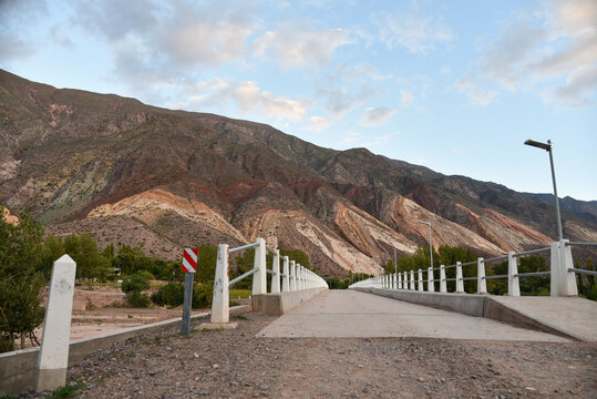 An urban bridge connecting a road to some colorful hills in Jujuy, Argentina.