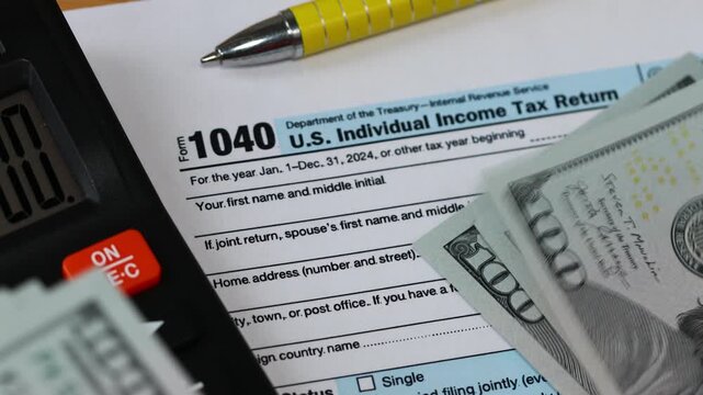  US Form 1040. Tax return and attachments. Financial concept. Counting dollars, calculator. Close up