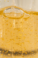 Skin care cosmetics product, 24k gold flakes components extraction. Skin care cosmetology dropper bottle close up.