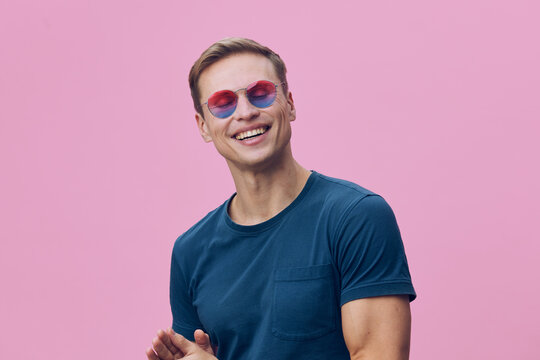 smiling man wear blue t-shirt and round colorful sunglasses isolated on pink background digital nomad freelance working concept - Powered by Adobe