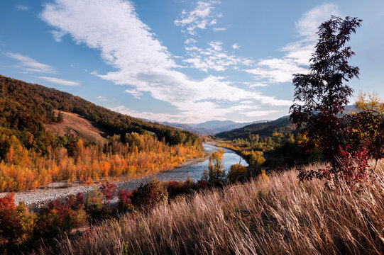 Autumn landscape along the Panaro river with colorful trees and hills, Emilia Romagna, Italy
