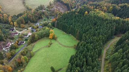 Aerial mountain valley village Travna Czechia autumn pull 1. Czech Republic, Czechia historically known as Bohemia. Central Europe. Autumn fall season. Farm rural area landscape. Mountain valley.