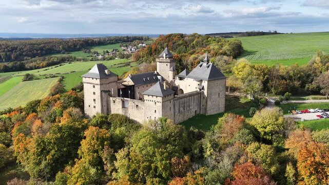 Vue a&eacute;rienne du superbe ch&acirc;teau de Malbrouck, sur les hauteurs du village de Manderen en Moselle. Mi-octobre le feuillage des arbres est aux couleurs de l'automne et le ciel est tr&egrave;s nuageux