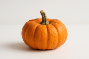 Obraz premium Small orange pumpkin on white background with natural light