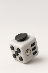 Modern fidget cube stress relief toy on neutral background
