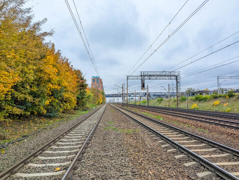 Warsaw, Poland, October 20, 2025. Railway tracks perspective with overhead electrical system and autumn scenery at Warszawska Kolej Dojazdowa WKD station Warsaw Poland. High quality photograph