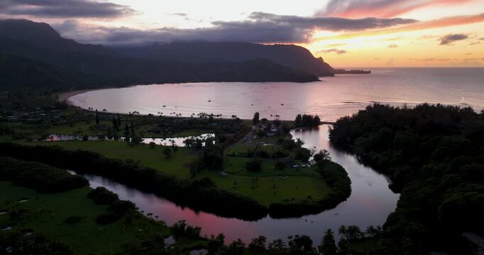 Rising Aerial View of Hanalei Bay Kauai Hawaii at Sunset with Mountains and Reflected Light