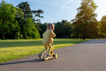 Girl on scooter. Riding child outdoor fun. Sunshine road freedom lifestyle.