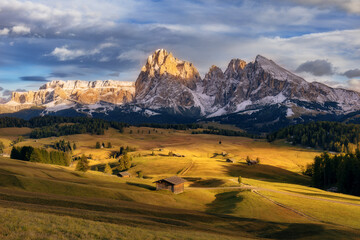 Beautiful view of mountain range on scenic Alpe di Siusi in golden light at sunset, Dolomites, South Tyrol, Italy. Horizontal photo.