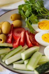 Fresh Healthy Meal with Eggs Cucumber Tomato Olives and Herbs